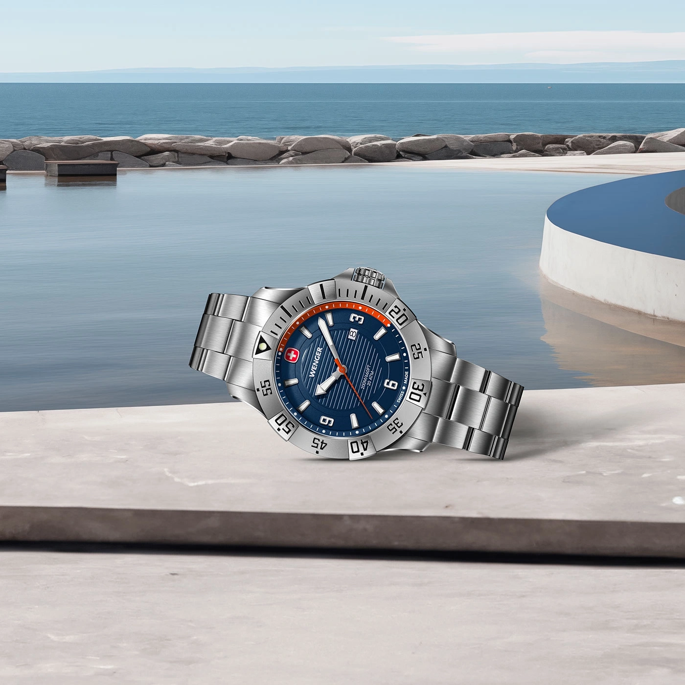 Uhr am Pool. Blaue Uhr mit silbernem Armband. Wasser und Himmel im Hintergrund.