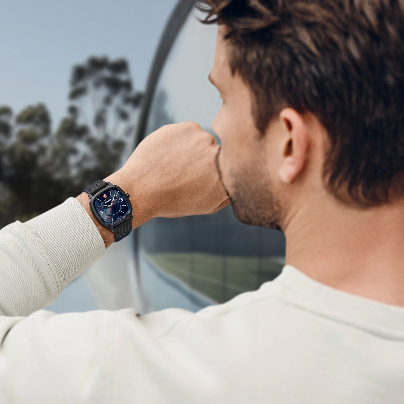 Mann mit Uhr, der aus dem Fenster schaut, Nahaufnahme