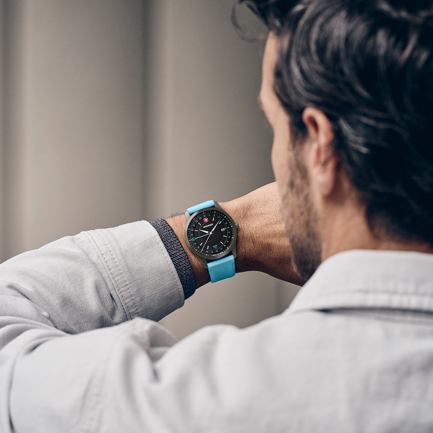 Mann trägt eine Uhr mit blauem Armband am Handgelenk.