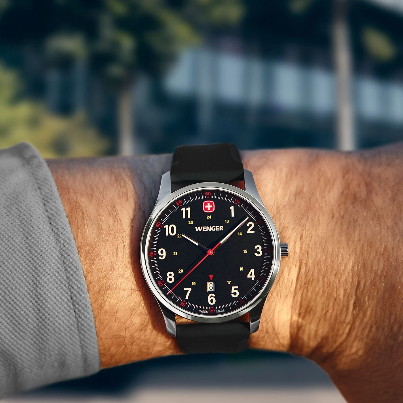 Wristwatch on wrist, black dial, red accents, Swiss brand, close-up shot