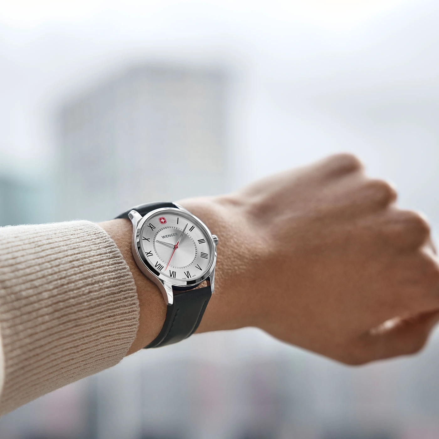 Uhr am Handgelenk, silbernes Zifferblatt, schwarzes Lederarmband, Wenger-Marke
