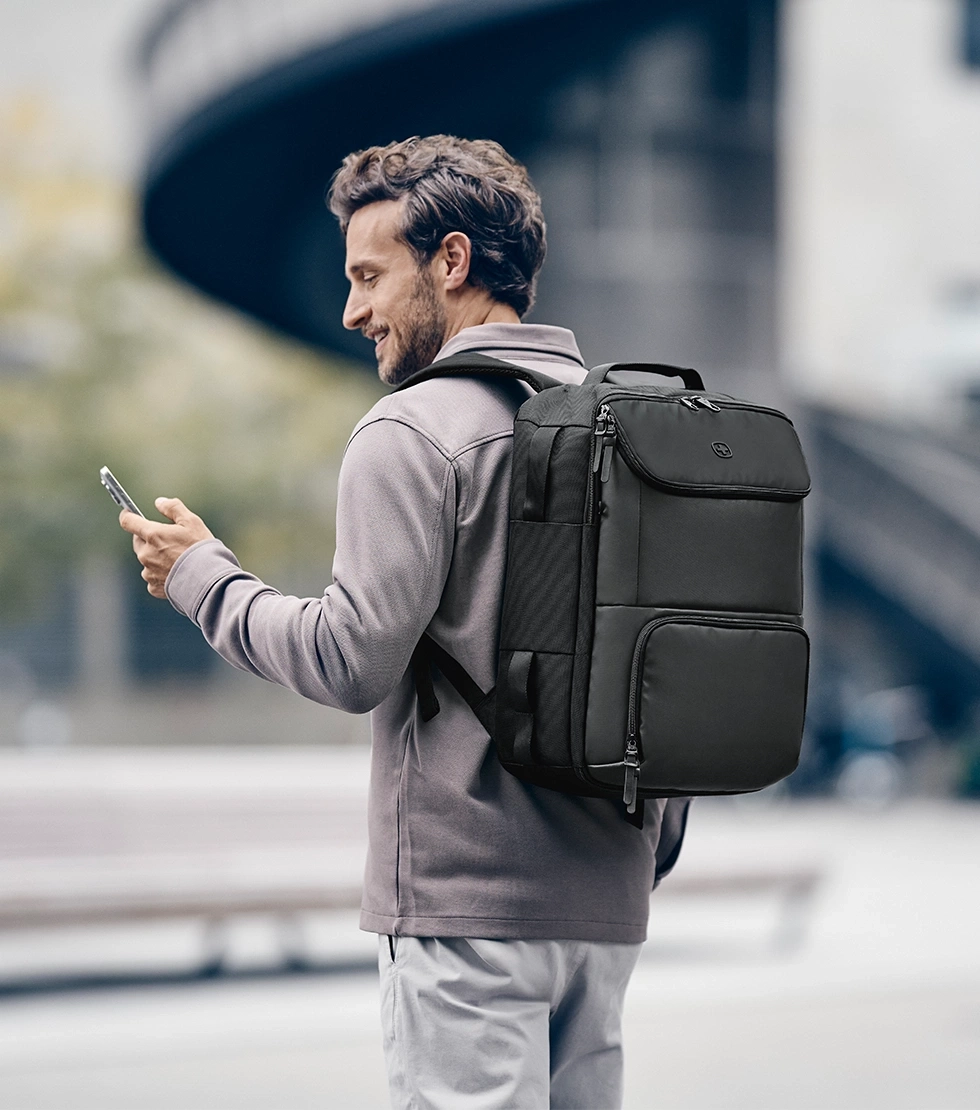 Ein Mann mit Rucksack und Handy auf der Straße