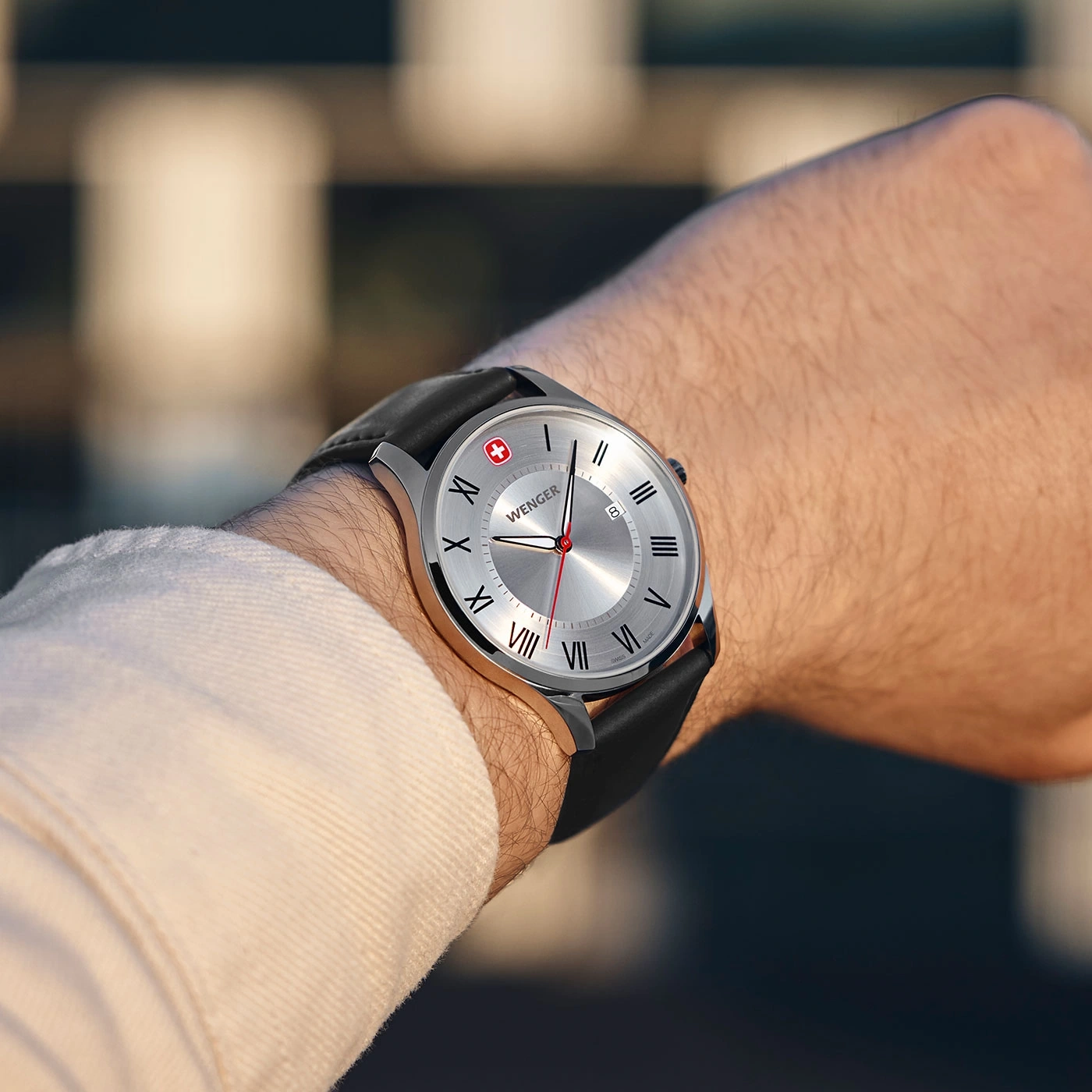 Wenger Uhr am Handgelenk, silbernes Zifferblatt, schwarzes Lederarmband, Schweizer Flagge