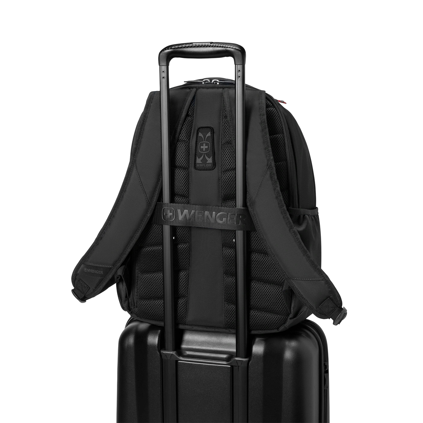 Schwarzer Rucksack auf einem schwarzen Koffer, mit dem Logo von Wenger.