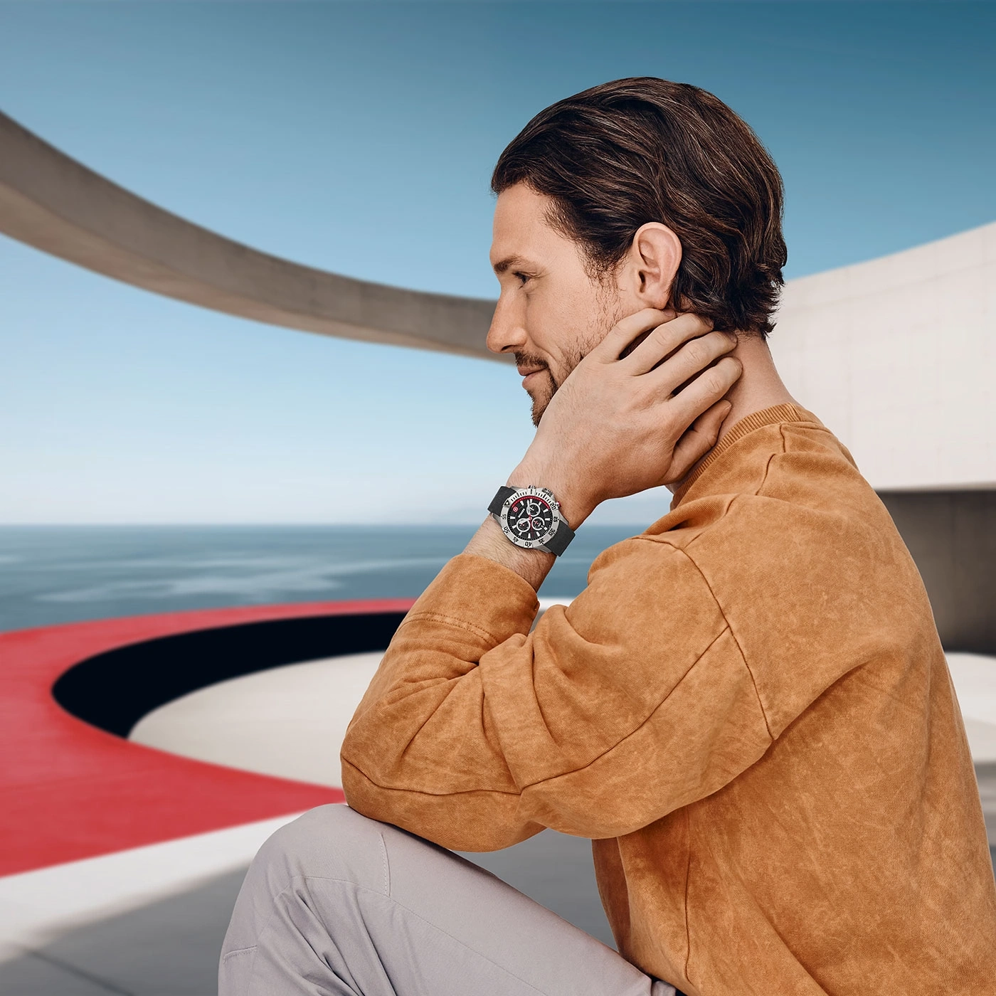Mann mit Uhr, der auf das Meer blickt, in einem modernen Gebäude