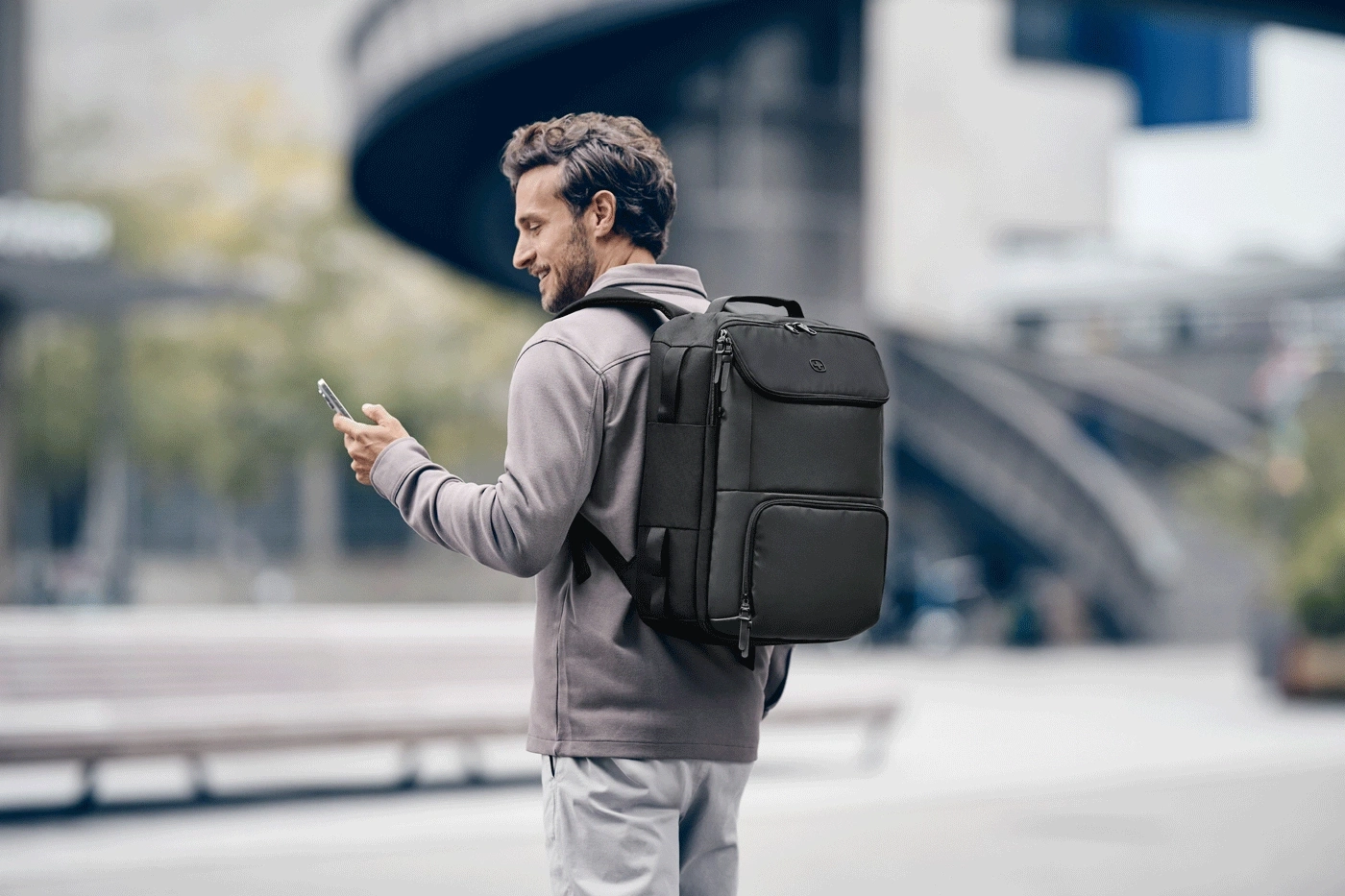 Ein Mann mit Rucksack und Handy im Freien