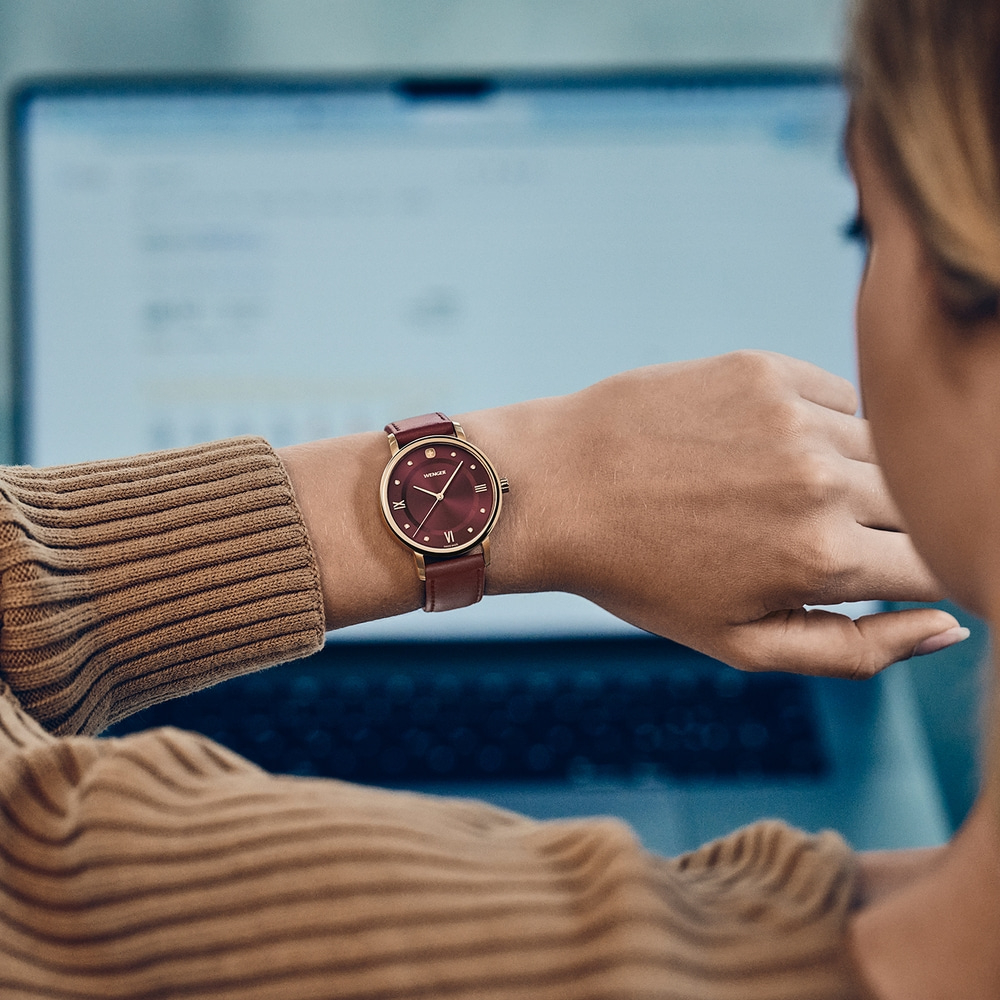 Une femme porte une montre en travaillant sur un ordinateur portable.