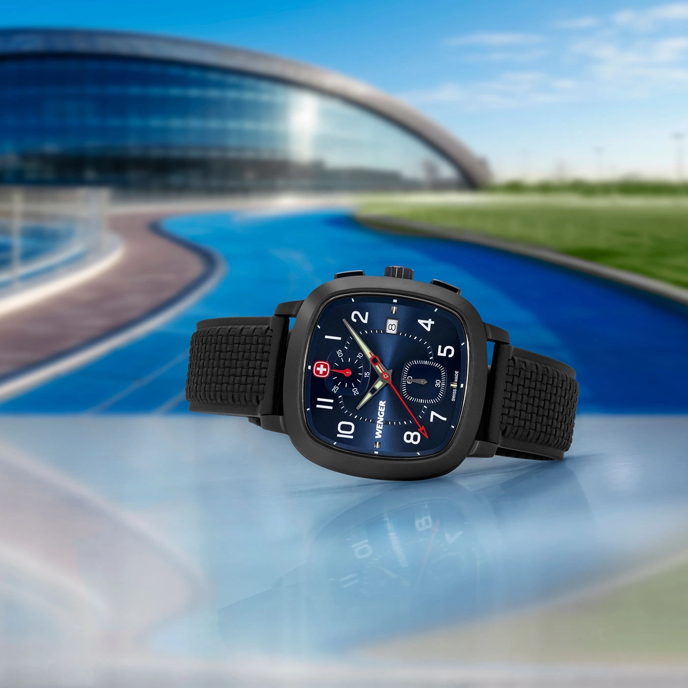 Wenger watch with black strap, blue dial, in front of a blurred background