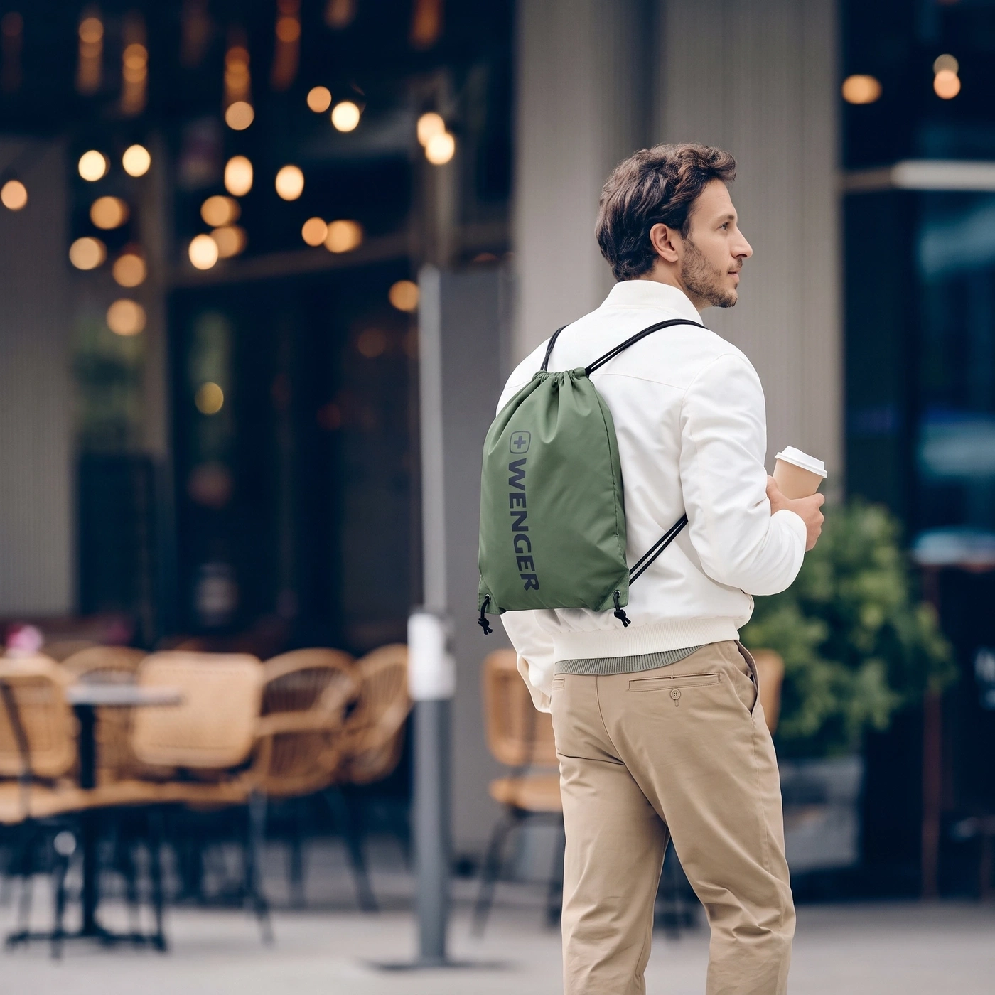 Man with backpack and coffee outdoors