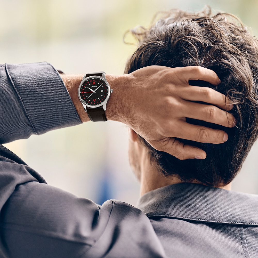 Mann kratzt sich mit Uhr am Kopf