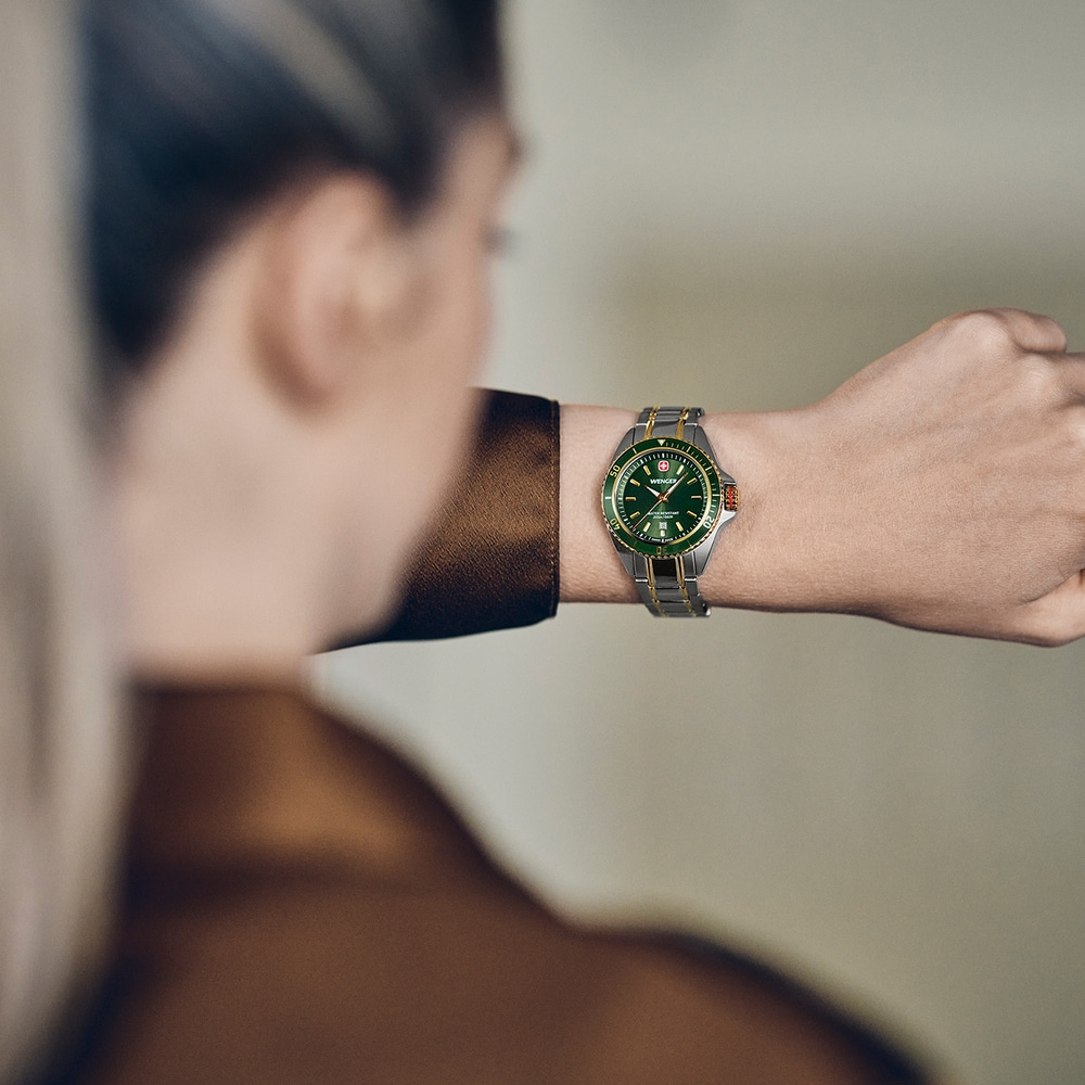 Un homme porte une montre-bracelet verte Wenger à son poignet.