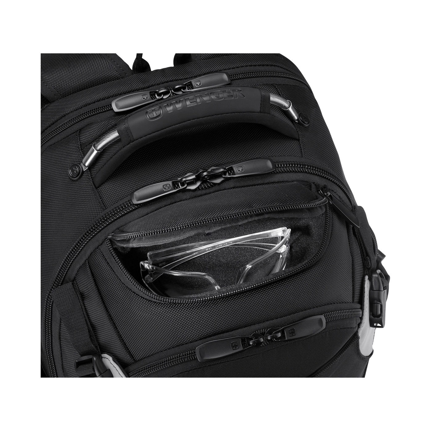 Nahaufnahme eines schwarzen Rucksacks mit Reißverschlüssen und einer Tasche mit Brille darin.